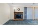 Living room featuring a classic brick fireplace and blue carpeting at 709 Falls Church Rd, Charlotte, NC 28270