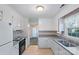 Functional kitchen with white cabinets, vintage appliances, and tile flooring at 709 Falls Church Rd, Charlotte, NC 28270