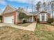 Brick ranch home with attached garage and landscaped yard at 7129 Spandril Ln, Charlotte, NC 28215