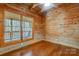 Cozy log cabin bedroom with wood walls and floors, large windows at 7404 Mockingbird Ln # 73, Waxhaw, NC 28173