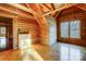 Log cabin bedroom with wood walls and floors, featuring a large window at 7404 Mockingbird Ln # 73, Waxhaw, NC 28173