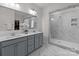 Modern bathroom with double vanity, large mirror, and walk-in tiled shower at 8138 Annsborough Nw Dr, Concord, NC 28027