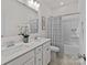 Bright bathroom featuring double sinks with white countertops and shower-tub combination at 8138 Annsborough Nw Dr, Concord, NC 28027