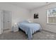 Cozy bedroom featuring carpeted floors, a blue quilt bed, and a bright window at 8138 Annsborough Nw Dr, Concord, NC 28027