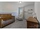 Cozy Bedroom with blue accent wall, crib, and ample natural light at 8138 Annsborough Nw Dr, Concord, NC 28027