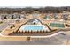 Aerial view of the community pool area with a clubhouse, playground, tennis courts, and parking at 8138 Annsborough Nw Dr, Concord, NC 28027