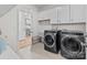 Well-equipped laundry room with modern washer and dryer, utility sink, and ample cabinet storage at 8138 Annsborough Nw Dr, Concord, NC 28027