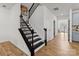 Foyer staircase with wood flooring, black painted banister, and natural light at 8138 Annsborough Nw Dr, Concord, NC 28027