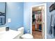 Bathroom with white vanity, toilet, and access to a walk-in closet at 824 Broad River Ln, Charlotte, NC 28211