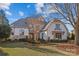 Two-story house with stone accents and a metal roof, showcasing a well-manicured lawn at 8904 Clavemorr Glenn Ct, Charlotte, NC 28226