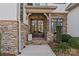 Inviting entryway with double doors, stonework, and landscaping at 8904 Clavemorr Glenn Ct, Charlotte, NC 28226