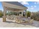 Covered patio with outdoor kitchen, seating, and fire pit at 8904 Clavemorr Glenn Ct, Charlotte, NC 28226