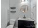 Small bathroom with white vanity and round mirror at 1010 Craven St, Indian Trail, NC 28079