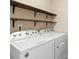 Bright laundry room with Whirlpool washer and dryer and wooden shelves at 1010 Craven St, Indian Trail, NC 28079