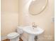 Powder room with pedestal sink and toilet at 11304 Lemmond Acres Dr, Mint Hill, NC 28227