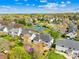 Aerial view of the home and community, including a lake, tennis courts, and pool at 14500 Harvington Dr, Huntersville, NC 28078