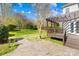 Backyard featuring a patio, wooden deck, green lawn, and wooded fence line at 14500 Harvington Dr, Huntersville, NC 28078