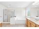Bright bathroom featuring a glass-enclosed shower, a soaking tub, and white vanity at 14500 Harvington Dr, Huntersville, NC 28078