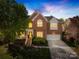 Charming two-story brick home featuring a well-manicured lawn and attached garage at 14500 Harvington Dr, Huntersville, NC 28078