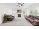 Comfortable living room featuring a fireplace, plush leather couches, and a ceiling fan at 14500 Harvington Dr, Huntersville, NC 28078