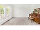 Cozy living room with a piano and ample natural light from a large window at 14500 Harvington Dr, Huntersville, NC 28078