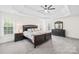 Spacious main bedroom with tray ceiling, lots of natural light and a dark wood furniture set at 14500 Harvington Dr, Huntersville, NC 28078