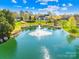 Beautiful pond view with fountain surrounded by lush greenery and landscaping at 14500 Harvington Dr, Huntersville, NC 28078