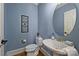 Elegant powder room with pedestal sink and oval mirror at 16512 Pelican Point Ln, Cornelius, NC 28031