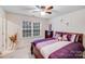 Cozy bedroom with a large window, purple bedding, and a ceiling fan at 16812 Lookout Landing Ln, Charlotte, NC 28278