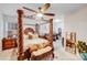The spacious bedroom features a four-poster bed, ceiling fan, and lots of natural light at 16812 Lookout Landing Ln, Charlotte, NC 28278
