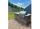 Outdoor kitchen featuring a built-in grill on a brick base with a granite countertop at 16812 Lookout Landing Ln, Charlotte, NC 28278