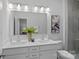 Bright bathroom features a double vanity with white countertops, modern fixtures, and decorative accents at 19765 Feriba Pl, Cornelius, NC 28031