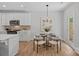 Eat-in kitchen with stainless appliances, white cabinets, and a modern lighting fixture at 19765 Feriba Pl, Cornelius, NC 28031