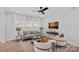 Inviting living room with neutral decor, large windows, and a sleek ceiling fan at 19765 Feriba Pl, Cornelius, NC 28031