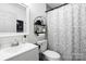 Well-lit bathroom featuring sleek fixtures, a patterned shower curtain, and decorative shelving for a modern feel at 3411 Rogers St, Charlotte, NC 28208