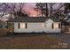 A beautifully presented single-story home with a picturesque sunset backdrop and a cozy front porch at 3411 Rogers St, Charlotte, NC 28208