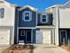 Modern two-story townhome with gray siding, white garage doors, and landscaping at 3520 Backwater St, Concord, NC 28027