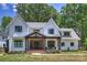 Two-story farmhouse with gray metal roof, brick accents, and a covered porch at 4311 Craig Ave, Charlotte, NC 28211