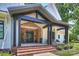 Covered front porch with brick steps, black columns, and stylish light fixture at 4311 Craig Ave, Charlotte, NC 28211