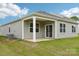 View of home's covered back patio, neutral siding, and lush green lawn at 4614 Harris Elliot Rd, Lincolnton, NC 28092
