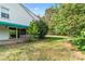 Backyard showcasing a patio, lush lawn, mature trees, and partial home exterior at 7000 Quail Hill Rd, Charlotte, NC 28210