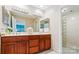Well-lit bathroom featuring a double vanity, tile floor, and a glass block shower at 7000 Quail Hill Rd, Charlotte, NC 28210