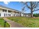 Stately white two-story home featuring black shutters, rocking chairs on the covered porch, and a beautiful large lawn at 7000 Quail Hill Rd, Charlotte, NC 28210