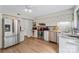 Well-lit kitchen features stainless steel appliances, white cabinetry, granite countertops, and stylish backsplash at 7000 Quail Hill Rd, Charlotte, NC 28210