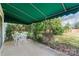 Inviting outdoor patio with a green awning, dining set, and view of lush greenery at 7000 Quail Hill Rd, Charlotte, NC 28210
