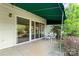 Outdoor patio featuring a dining set, green awning, sliding glass door, and yard at 7000 Quail Hill Rd, Charlotte, NC 28210