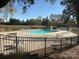 Community pool with lounge chairs and tables, surrounded by lush landscaping and a secure fence at 7000 Quail Hill Rd, Charlotte, NC 28210