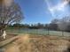 View of two tennis courts surrounded by a black fence with a blue sky overhead at 7000 Quail Hill Rd, Charlotte, NC 28210