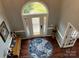 Two-story entryway with hardwood floors, decorative rug, and arched window at 7705 Windsor Forest Pl, Harrisburg, NC 28075