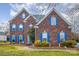 Two-story brick home with blue shutters and manicured landscaping at 7705 Windsor Forest Pl, Harrisburg, NC 28075